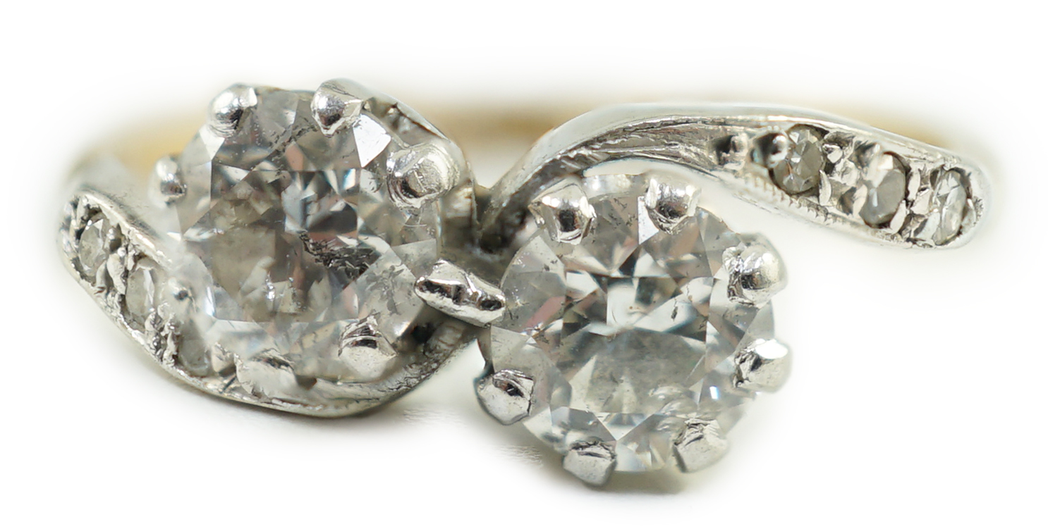 A mid 20th century 18ct gold, platinum and two stone diamond set crossover ring